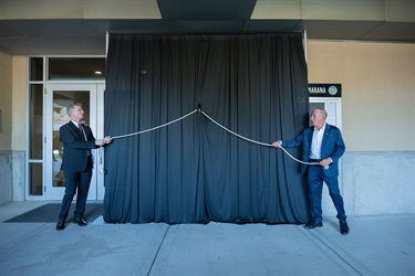Town Manager Terry Rozema and Mayor Jon Post start to reveal the plaque