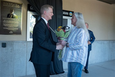 Town Manager Terry Rozema gives flowers to Pam Branlett, Ed Honea's sister