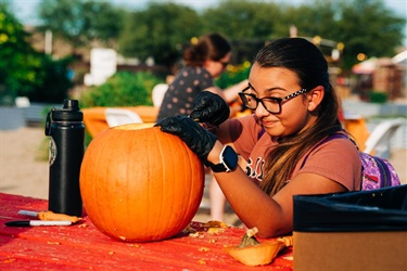 Young girl carving a pumpkin