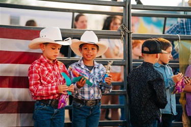 Young boys in cowboy hats with mutton bustin' trophies