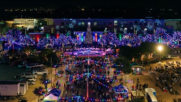Drone aerial view of Mistletoe Market and the Tree Lit up in front of the complex