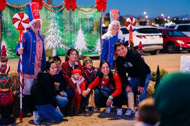 Family poses in front of Holiday Festival photo set