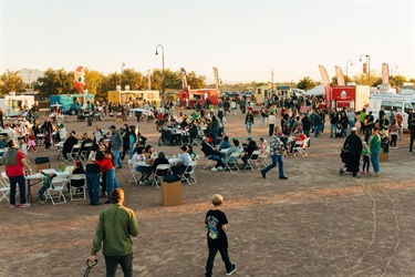 Wide view of people sitting near food trucks