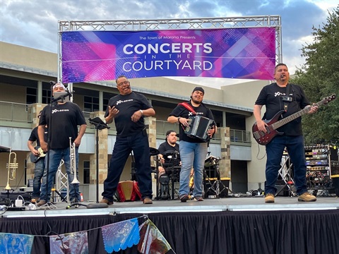 The band XPLOSION performing on stage at Concerts in the Courtyard in 2023.